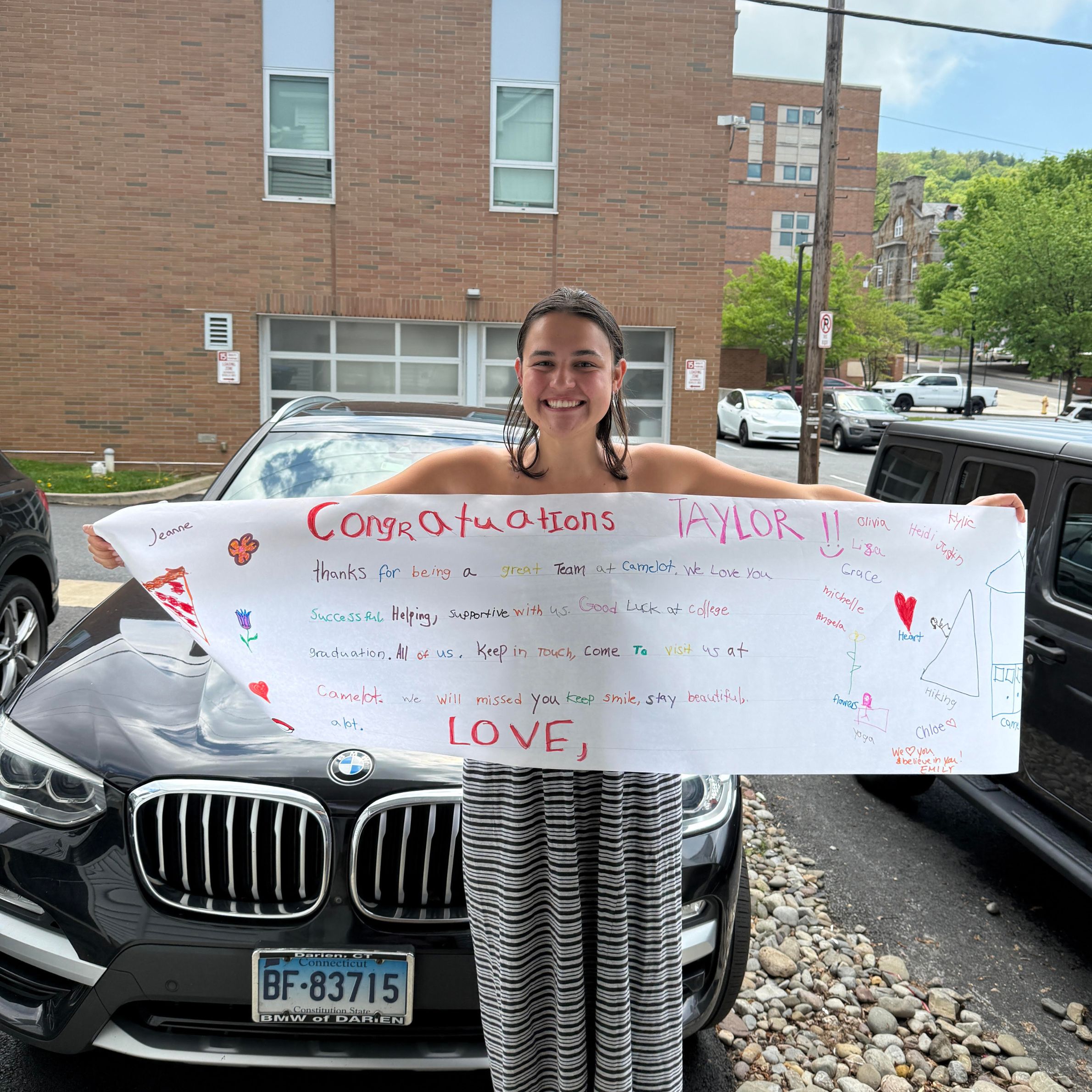 Image of Taylor Crompton holding a congratulations banner